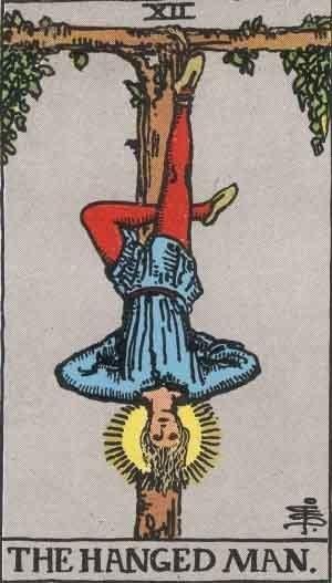 An artistic representation of the hanged man tarot card meaning, depicting a figure suspended upside down.